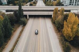 An aerial view of a car driving on a highway photo