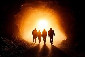 People walking through a tunnel with the sun shining through photo