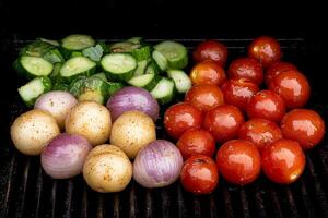 Tomatoes, cucumbers, and onions on a grill photo