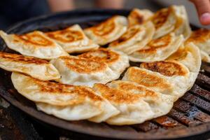 A person is holding a pan with dumplings on it photo