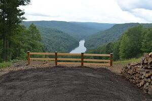A wooden fence with a wooden gate in front of a river photo