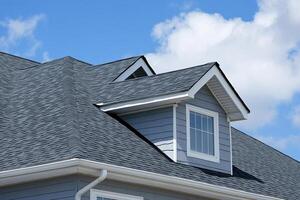 A roof with a gray shingled roof and a white window photo