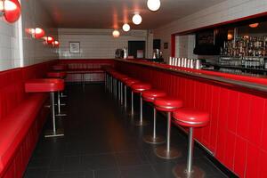 A long bar with red seats and a counter photo