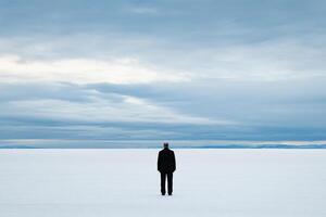 A man standing in the middle of a large field photo