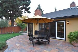 A patio with a table and chairs under an umbrella photo