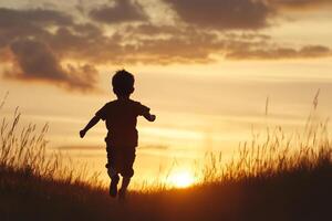 A child running in the grass at sunset photo