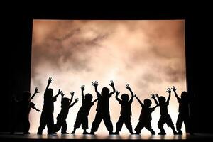 Silhouette of children on stage with hands up photo