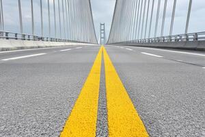 A yellow line on the side of a bridge photo