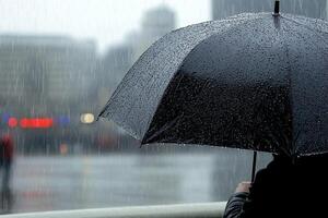 A person holding an umbrella in the rain photo