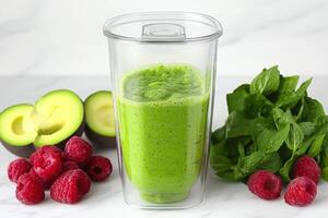 A blender filled with green smoothie and raspberries photo