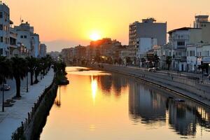 The sun is setting over a canal in a city photo