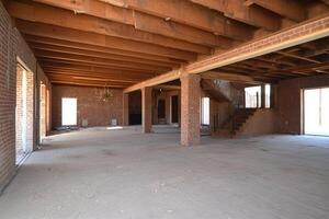 An empty room with exposed beams and wood floors photo