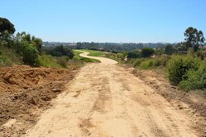 A dirt road with a dirt path on the side photo