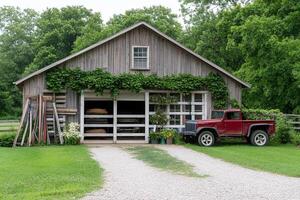 A red truck sits in front of a barn photo
