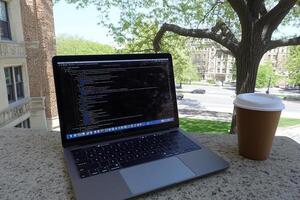 A laptop computer and a cup of coffee on a ledge photo