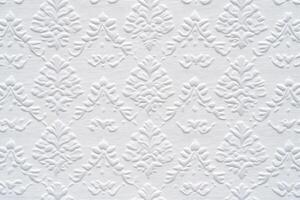 A white wall with a pattern of leaves photo