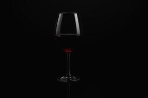 Glass of Red Wine on Black Background with Elegant Lighting photo