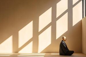 Buddhist monk meditating in a room with window light shadows photo