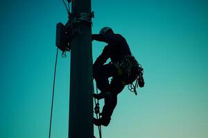 Technician climbing utility pole installing telecommunication equipment photo