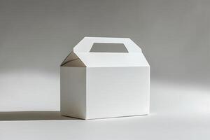 White cardboard box with handle on gray background photo