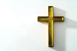 Golden christian cross casting a shadow on white background photo