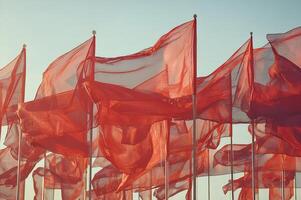 Red flags waving in the wind against a clear sky photo