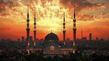 The sun sets over a mosque in the middle of a city photo