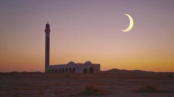 A mosque and crescent in the desert at sunset photo