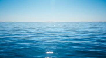 A view of the ocean with a bright sun shining over it photo