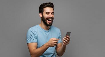 A man with a beard and a blue shirt is laughing while holding a cell phone photo