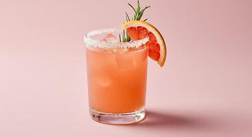 A pink drink with a slice of orange and rosemary garnish photo