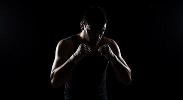 A man in a black tank top and boxing gloves photo