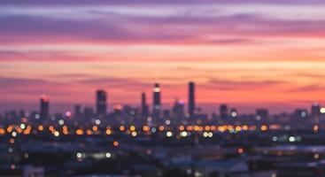 A city skyline at sunset with lights on the buildings photo