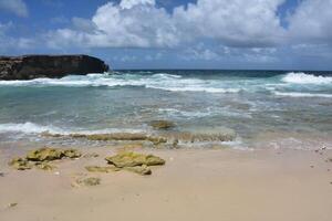 Waves Rolling Ashore Under Puffy White Clouds photo