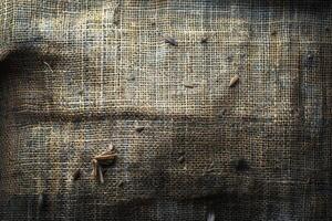 Close-up view of a textured, worn burlap fabric surface. photo