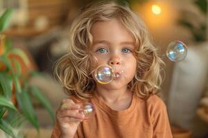 A young child blowing colorful bubbles in a home setting. photo