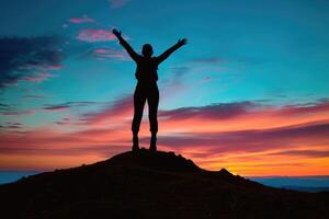 Silhouette of a person celebrating on a mountaintop at sunrise. photo