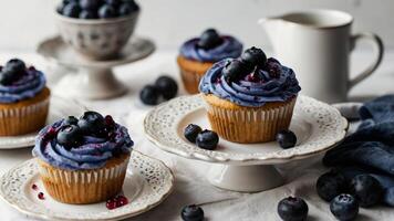 Cupcakes with blue frosting and blueberries on a white plate photo