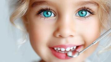 A little girl with blue eyes is holding a toothbrush photo