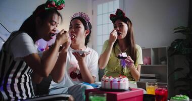 Handheld shot, Three friends are enjoying cake on a sofa in a warmly decorated room at home. Share special moments together at home video