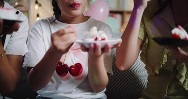 Handheld shot, Three friends are enjoying a cake on a sofa in a warmly decorated room at home. Share special moments together at home video