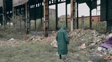pessoa dentro químico protetora terno caminhando dentro distraído lugar. sobrevivente dentro abandonado Lugar, colocar com pilhas do lixo a partir de arruinado edifícios. apocalipse conceito. video