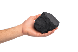 A hand holding a dark, solid chunk of coal, showcasing its rough texture and geometric shape. png