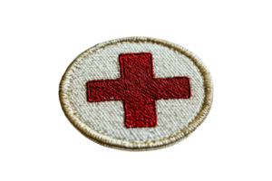 A circular embroidered patch featuring a prominent red cross on a beige background. png