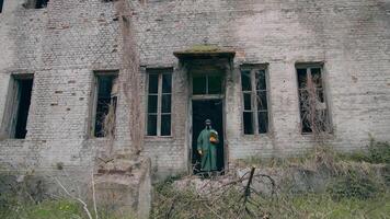virologista dentro radioativo zona. homem dentro protetora terno dentro quebrado prédio. sobrevivente segurando flores dentro mãos dentro abandonado lugar. químico ataque. video