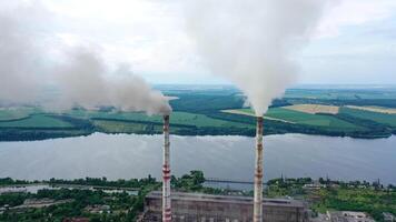 White stack of smoke coming out from large chimneys. Factory chimneys releases harmful emissions into the atmosphere on nature backdrop.Environmental problems. video