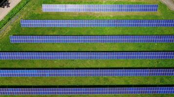 Innovative solar panels in rows on field. Blue sunny batteries receive ecological energy from sun. Motion camera to the right. View from above. video