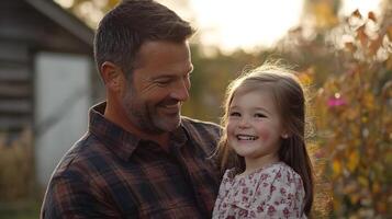 A man and a little girl smile together in a field photo