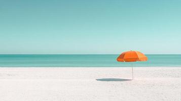 An orange umbrella on the beach with the ocean in the background photo