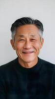 An asian man smiling in a black sweater photo